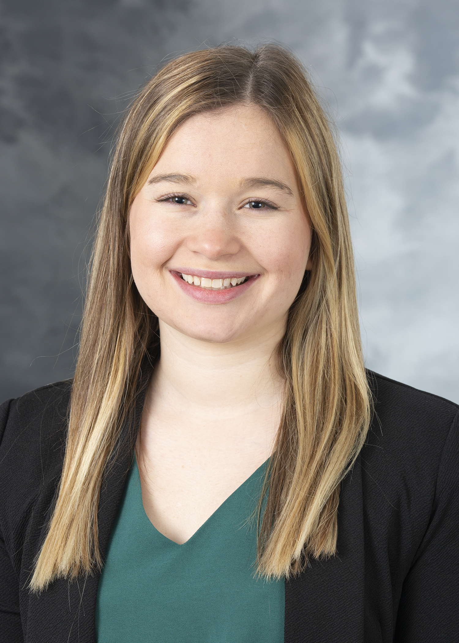 Jenna Schwab, Smiling woman with sandy blonde hair, wearing a teal colored shirt and a black blazer.