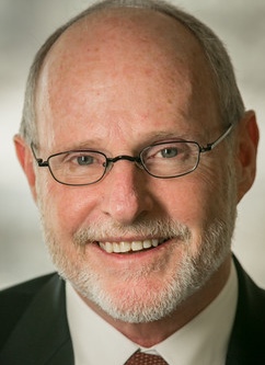James Shepherd, Smiling man with light brown hair, a beard and glasses wearing a suit with a red tie.