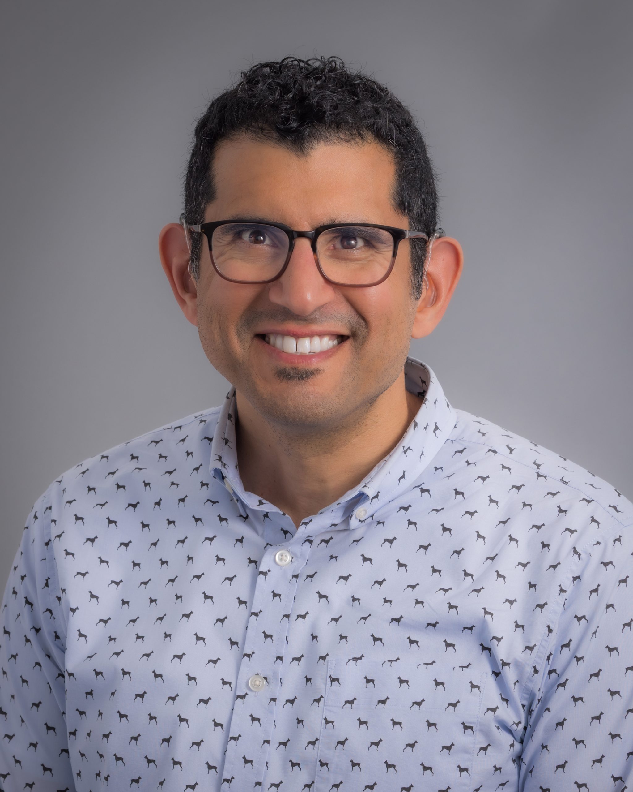 Ruben Mota, smiling man with brown skin and black wavy hair.